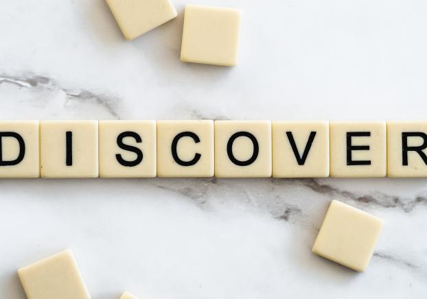 Tiles on a marble counter spelling out "discover"